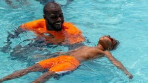 Commanders left tackle Cornelius Lucas teaches boys how to swim